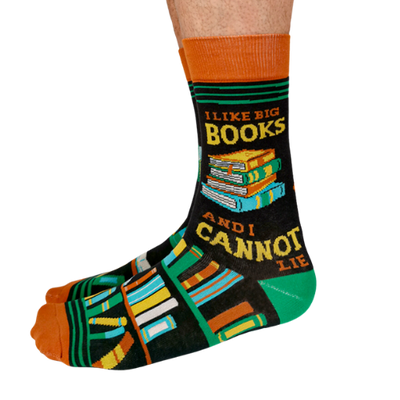 Pair of men's crew socks in orange, green, and black with a bookshelf design and the phrase 'I Like Big Books and I Cannot Lie' displayed on the side.