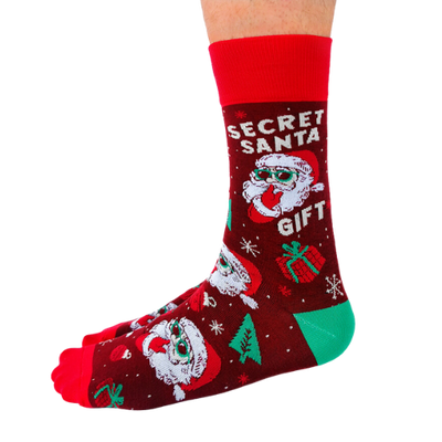 Red and green Secret Santa gift socks featuring a playful Santa design with sunglasses, snowflakes, and festive decorations, perfect for holiday gifting.